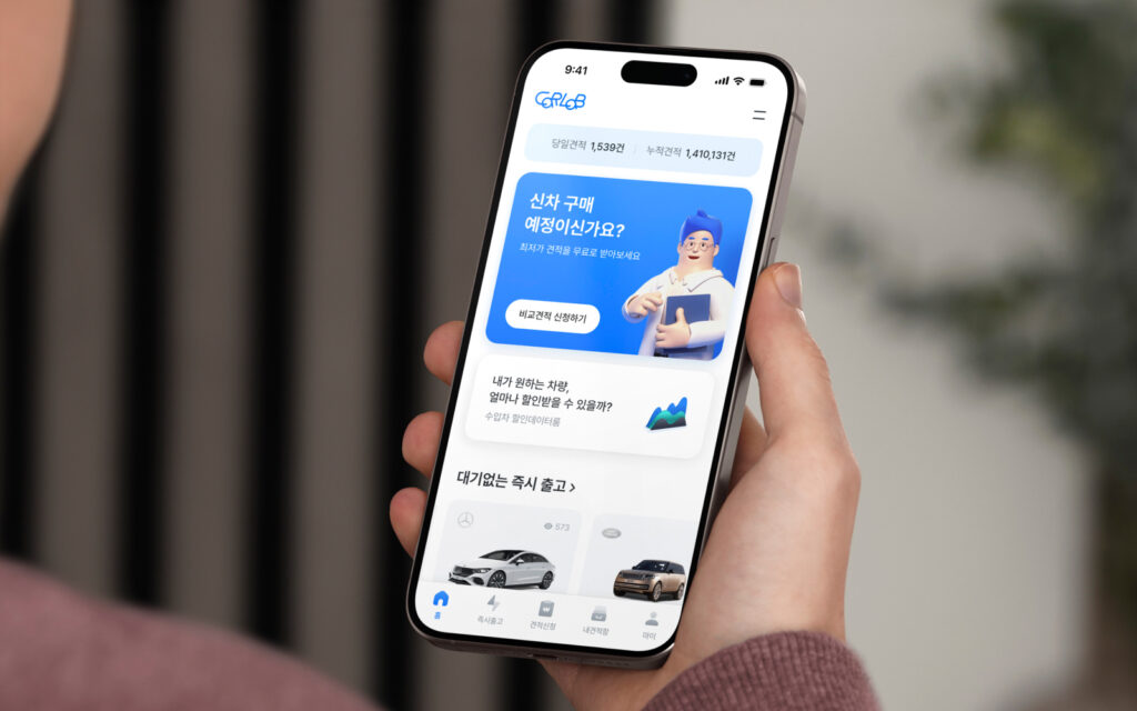 집 안 소파에 앉아 스마트폰 카랩(Carlab) 앱으로 간편하게 신차 견적을 비교하는 스마트한 운전자의 모습